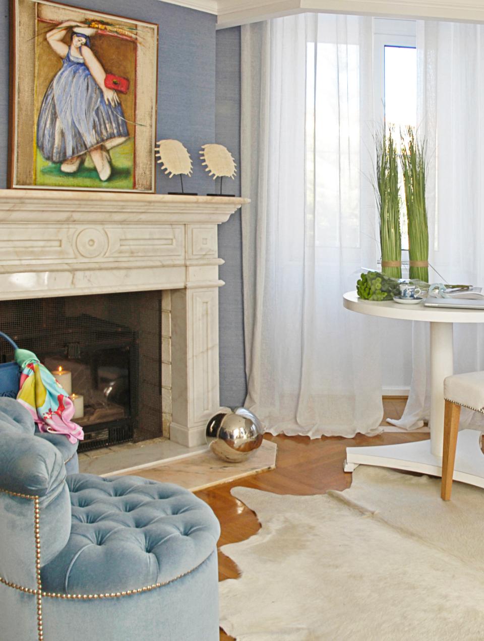 Decoração de sala em tons de azul e branco em que as elegantes cortinas até ao teto, conferem leveza e conforto ao ambiente