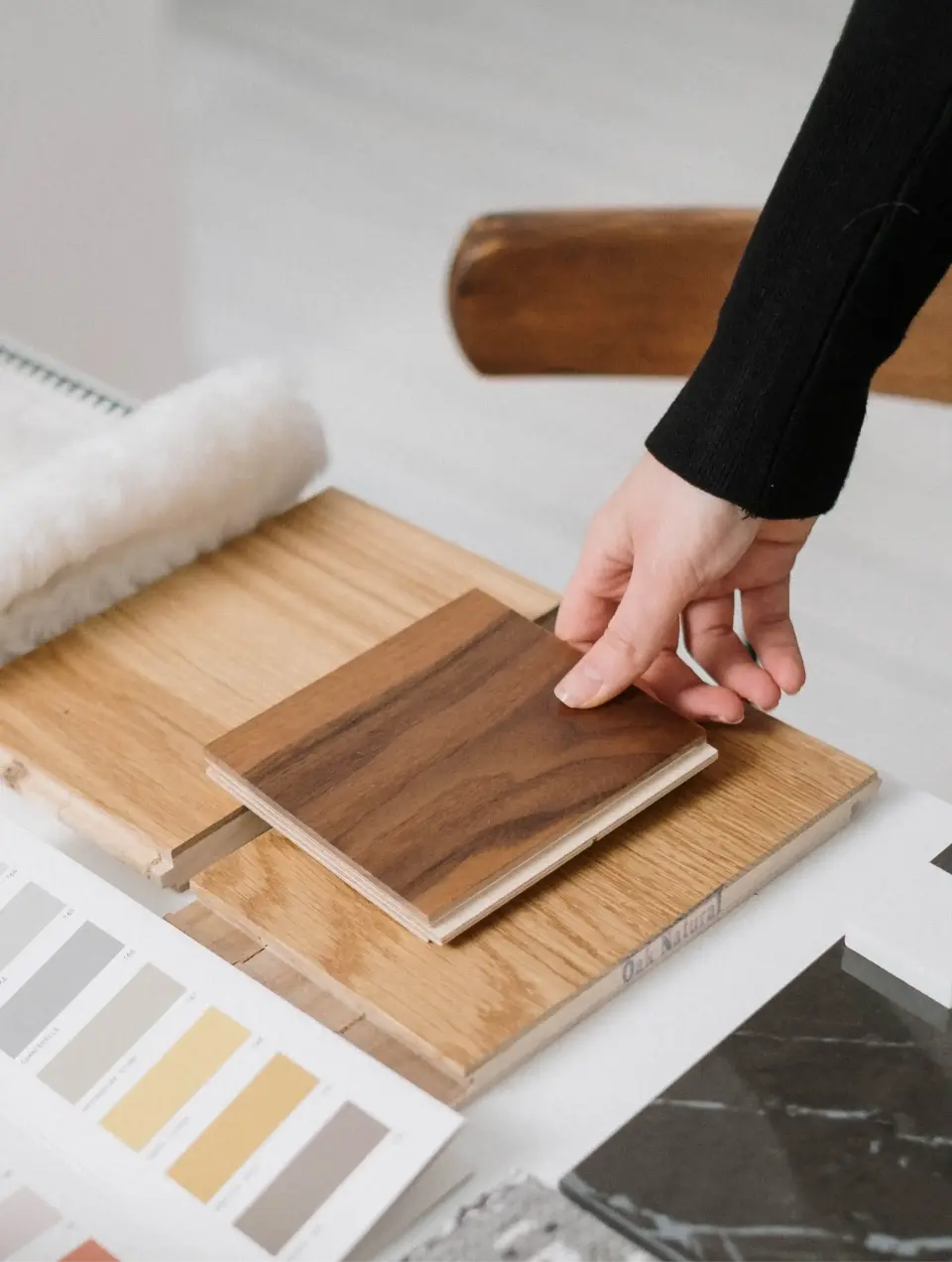 Samples of walnut wod, oak wood, black marble, and colors for a commercial project mood board