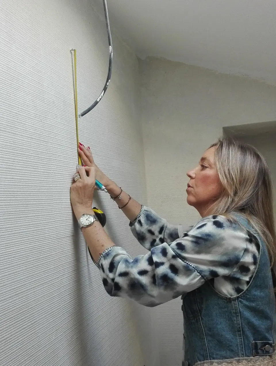 Arquiteta de Interiores Margarida Bugarim a fazer marcações de pontos de luz na parede de uma casa de banho em obras