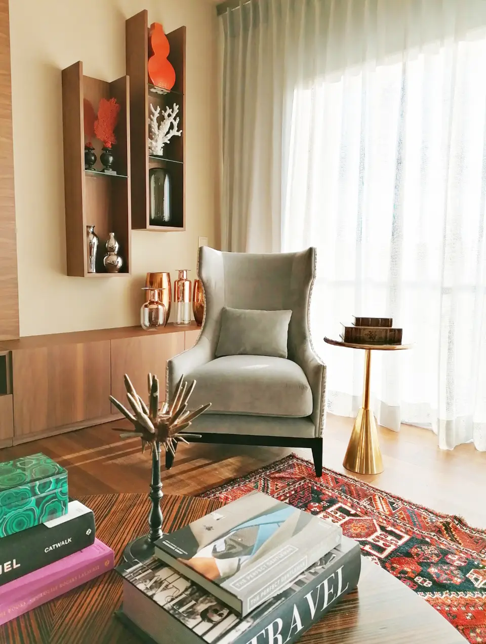 Interior design of the reading corner in the living room with an armchair, bookcase with decorative items and coffee table 