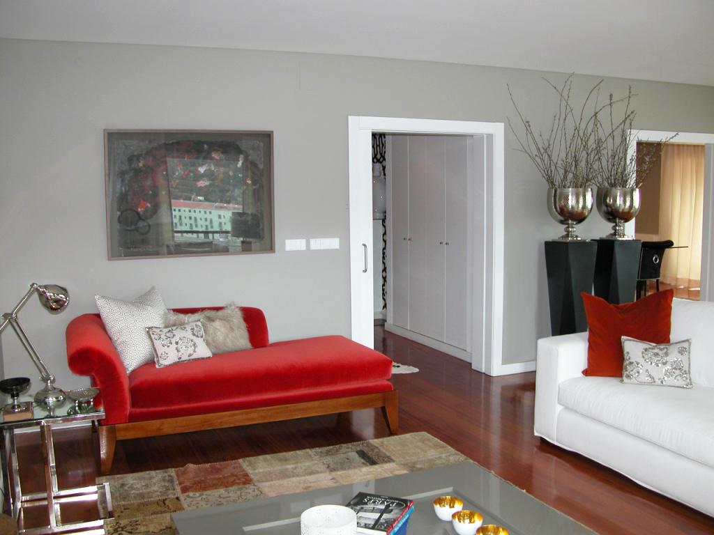 Living room décor with white sofa and red chaise longue, patchwork rug and grey lacquered coffee table