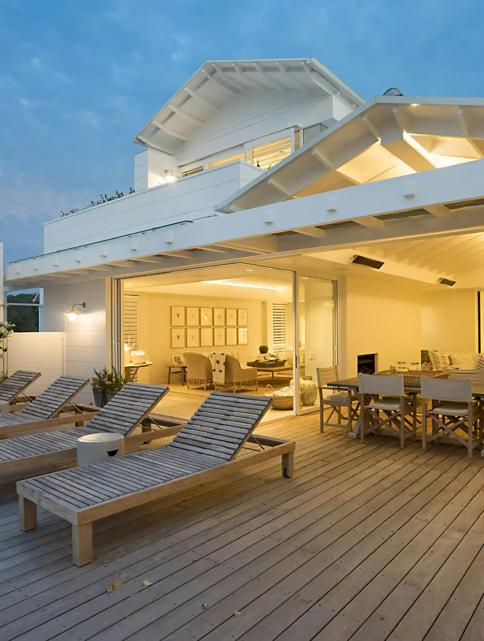 Outdoor porch area with a wooden pool deck and wooden lounge chairs