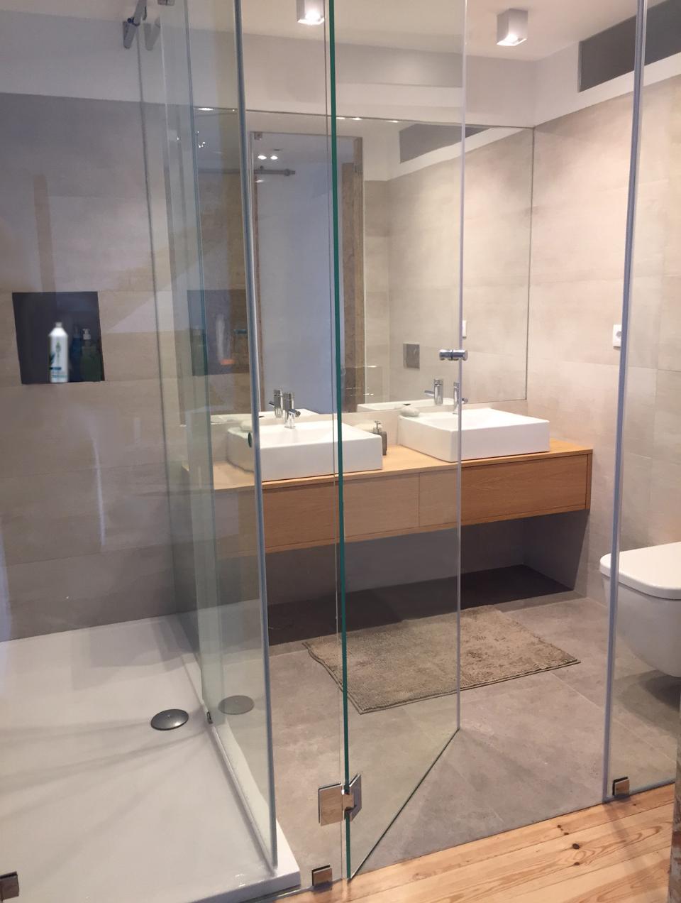 Bathroom with ceramic floor and wall tiles featuring a microcement finish and an oak vanity unit