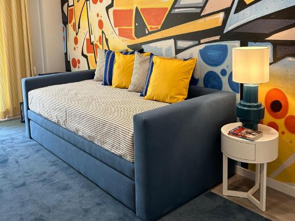 Decoração de quarto infantil em tons de amarelo e azul, o mural de grafitti transmite a personalidade do nosso cliente.