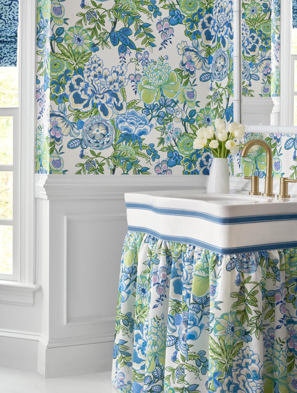 Decoração de casa de banho social de inspiração classica com lambrim de madeira branca e papel de parede floral em tons de azul e verde