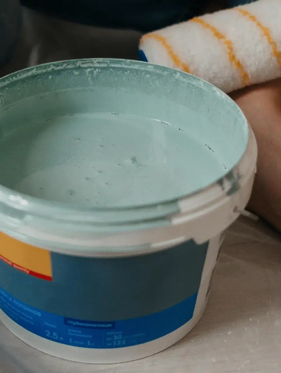 Pail of sage green paint for wall painting on a construction site