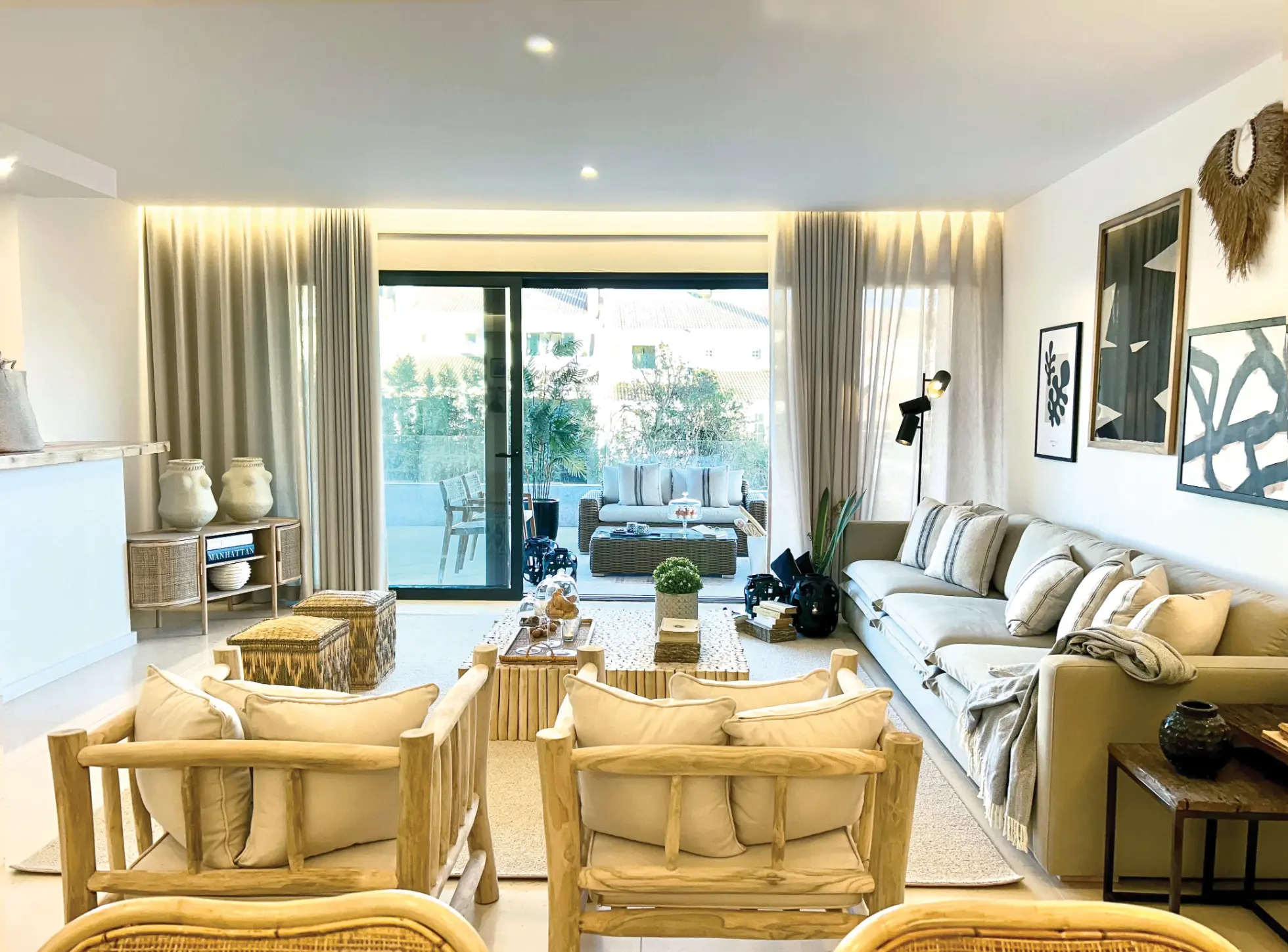 Decoração de sala de apartamento com estilo confortável e elementos naturais, sofá em tecido de algodão de tom beige, cadeirões de troncos