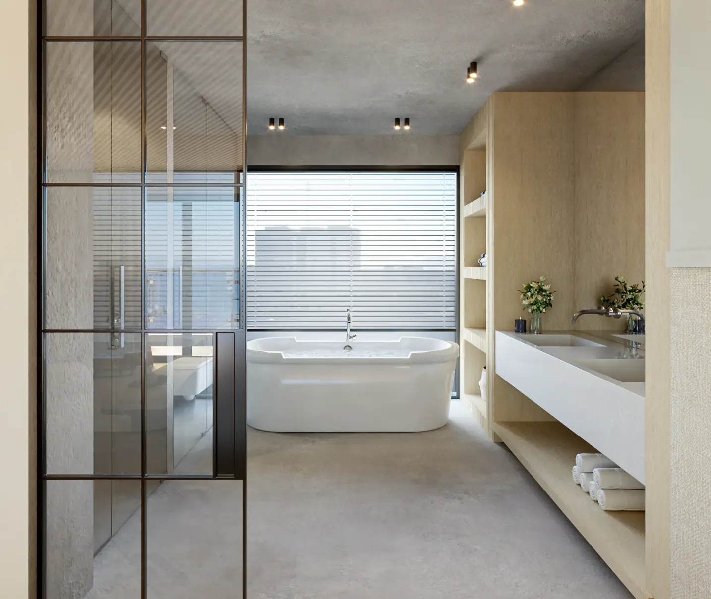 Casa de banho contemporânea com banheira free stand, pavimento, paredes e teto em microcimento e porta industrial em vidro e ferro