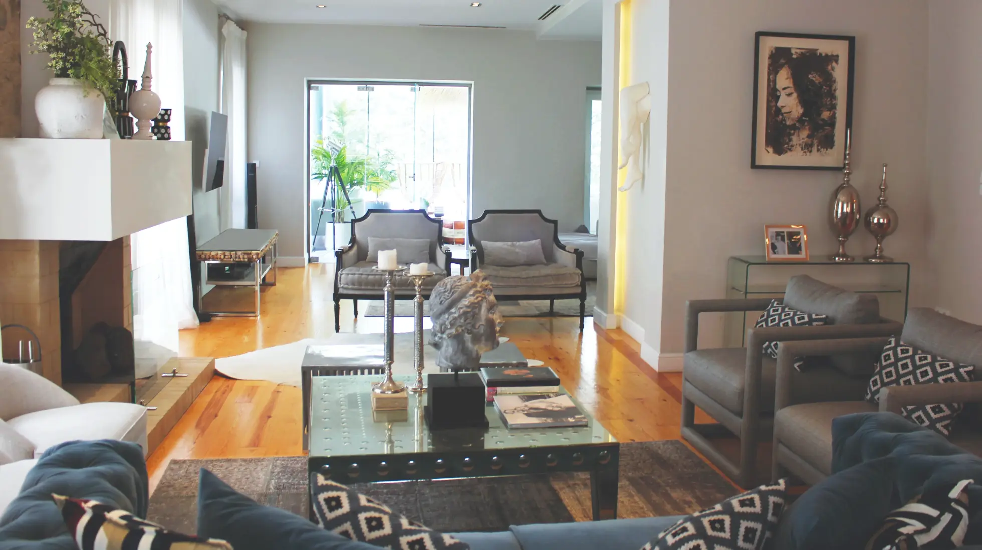 Sala de estar em moradia de luxo, decoração contemporânea com apontamentos clássicos, cadeirões, mesa de centro em espelho e escultura personalizada