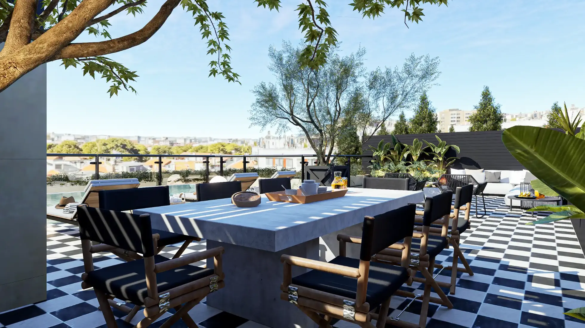 Zona de refeições de terraço com mesa em fibra cinza e cadeiras de realizador, pavimento em xadrez preto e branco e vegetação tropical a contornar 