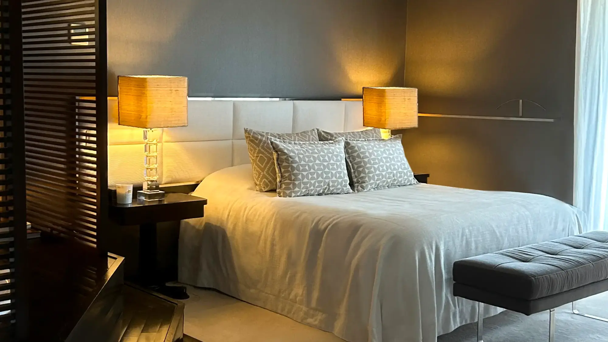 Quarto de casal com decoração sofisticada em tons neutros, alcatifa branca, cabeceira estofada e jacuzzi- projeto de interiores de Margarida Bugarim