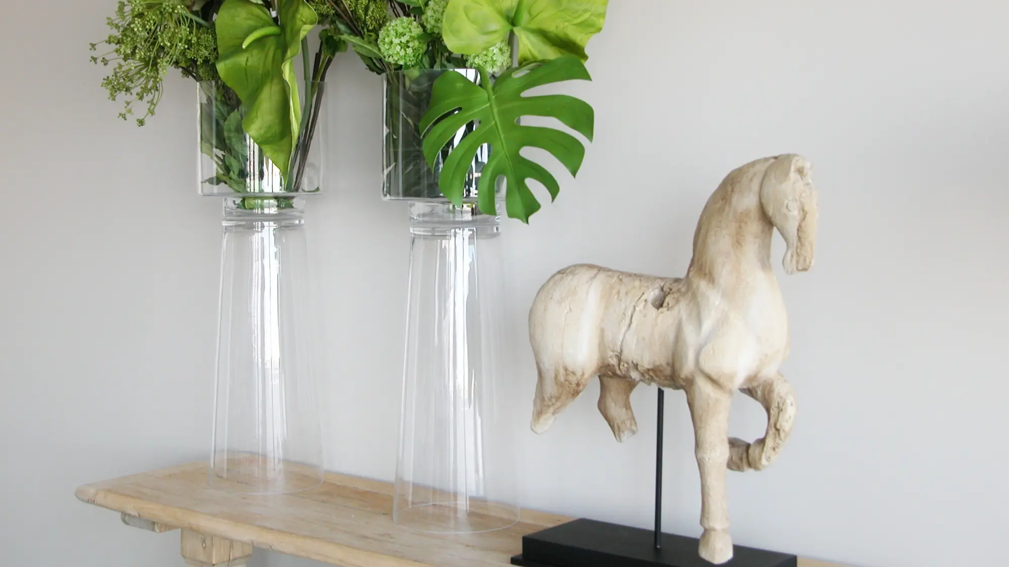 Detalhe de peças decorativas: Escultura de cavalo em madeira e arranjo floral de verdura -decoração assinada por Margarida Bugarim